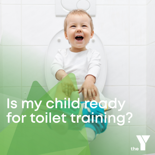 A toddler sitting on the toilet laughing