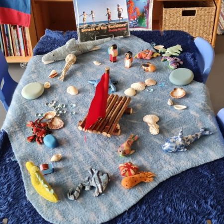 Inside the centre: An activity table with marine themed toys on a blue blanket